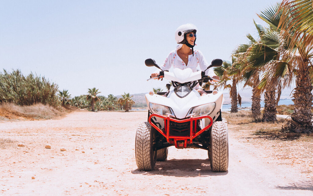 woman riding quad bike on a beach