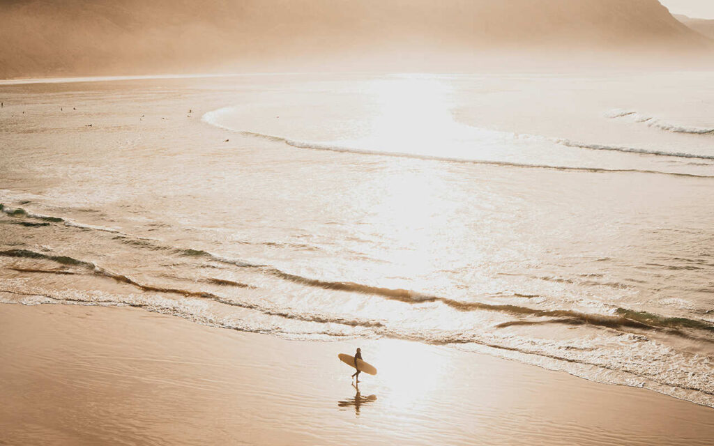 a surfer walking on the sunset in imsouane morocco