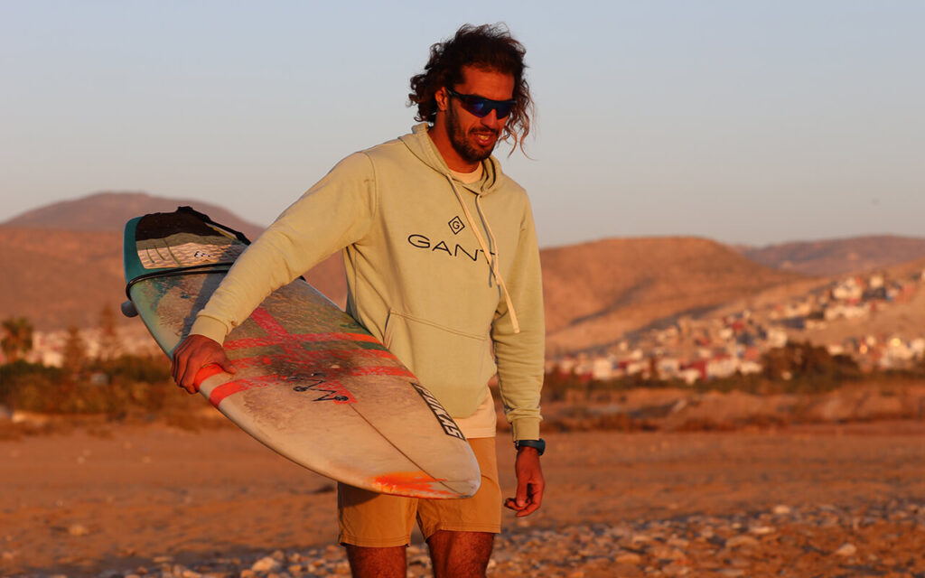 surfer walking on the beach with his shortboard