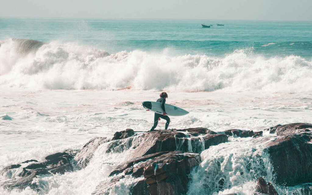 surfer with a shortboard in Anchor Point surf spot in Taghazout Bay surf village, Morocco