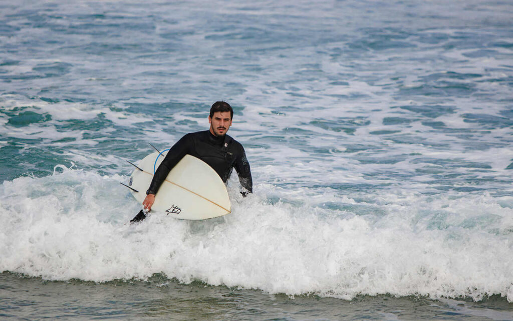 agadir surfing surfer going out of the water with a shortboard