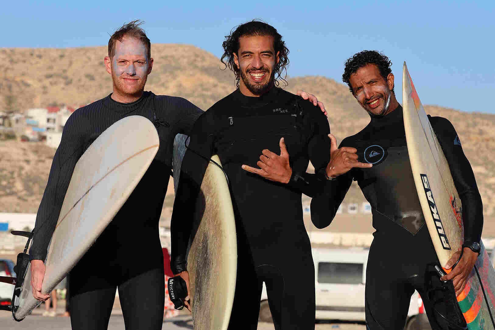 surfers in banana point surf spot tamraght, morocco