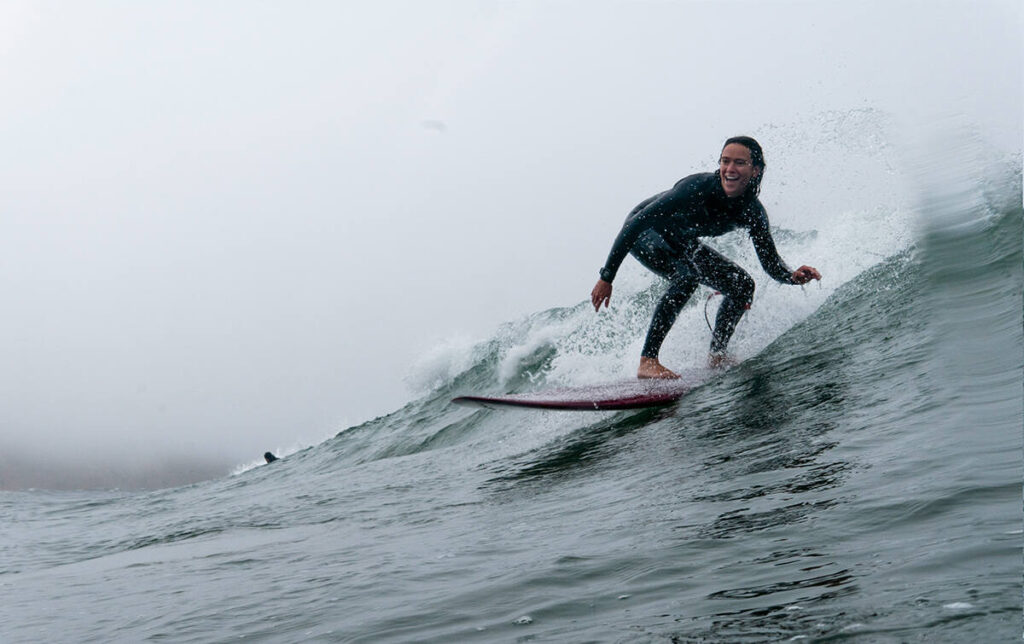 a surfer girl riding the wave and smiling